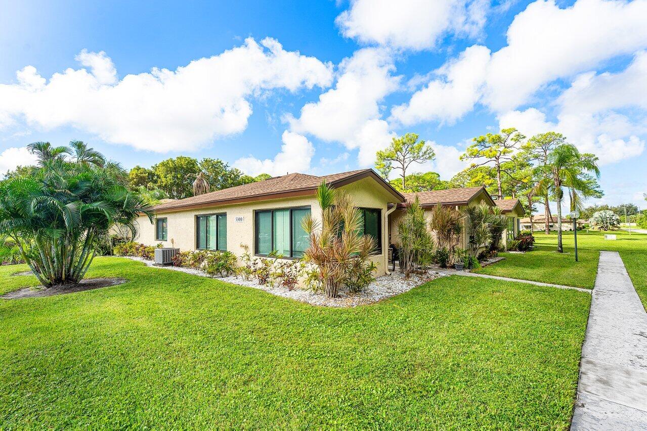 5300 Nesting Way, Unit A Delray Beach, FL 33484 - Photo 24 of 53 a front view of a house with garden