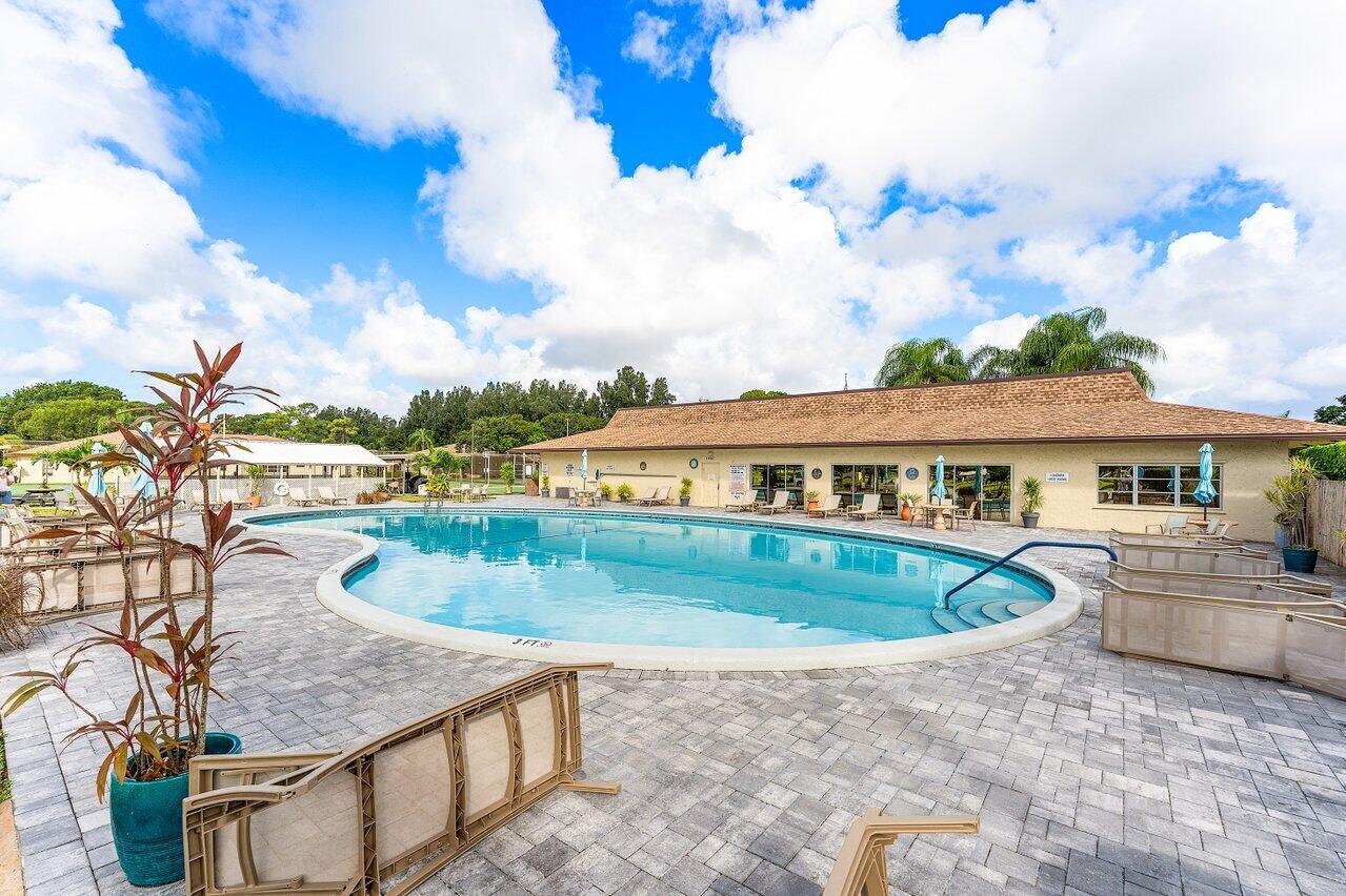 5300 Nesting Way, Unit A Delray Beach, FL 33484 - Photo 29 of 53 a view of a swimming pool with a patio