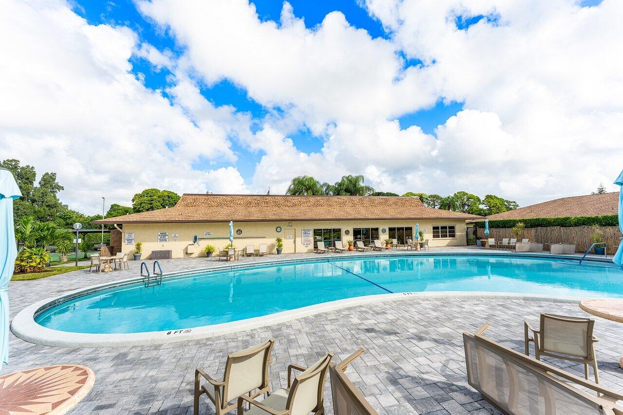 5300 Nesting Way, Unit A Delray Beach, FL 33484 - Photo 31 of 53 a view of a swimming pool and a garden