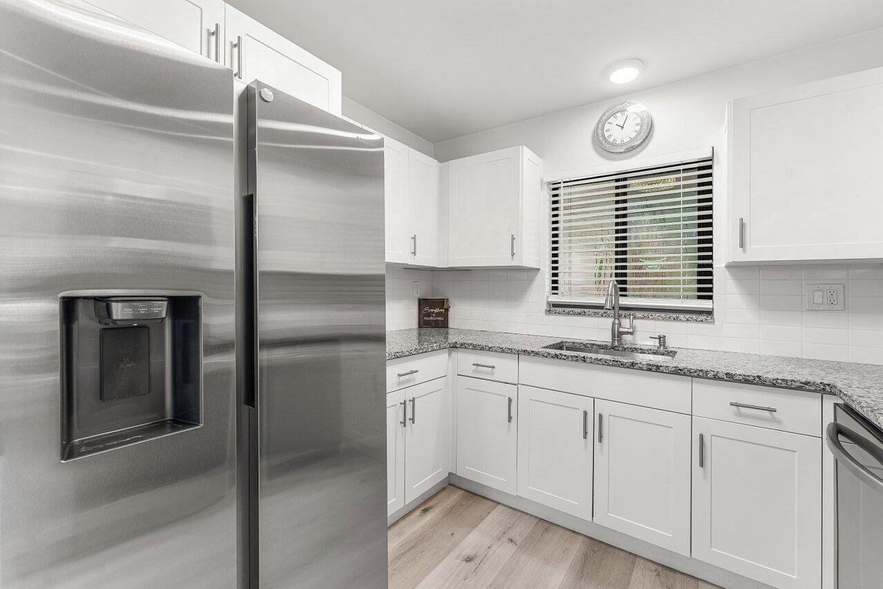 5300 Nesting Way, Unit A Delray Beach, FL 33484 - Photo 7 of 53 a kitchen with granite countertop stainless steel appliances cabinets a sink and a window