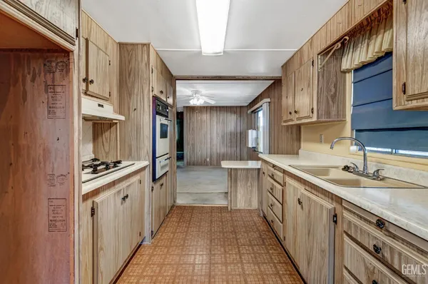 a kitchen with granite countertop a sink stove and cabinets