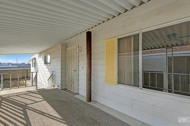 an empty room with ceiling fan and windows