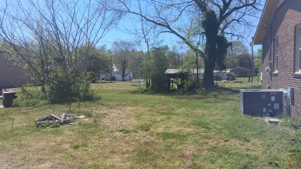 a backyard of a house with table and chairs