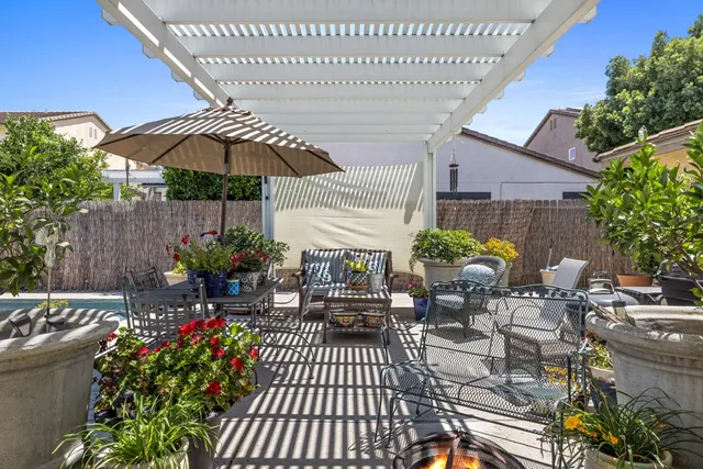 a view of a patio with table and chairs under an umbrella