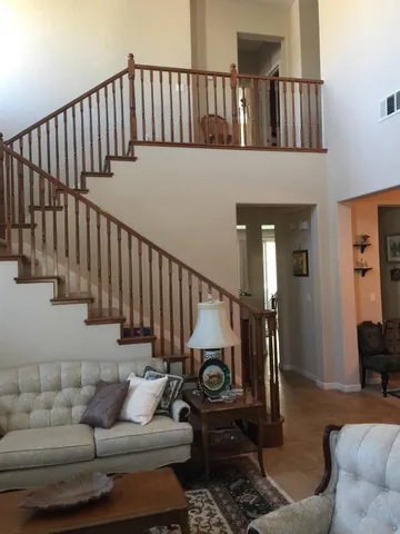 a living room with couches and a dining table with wooden floor