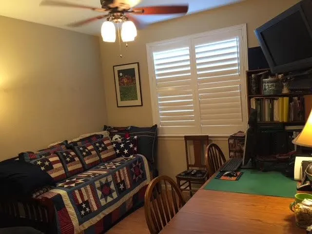 a bedroom with a bed window and flat screen tv