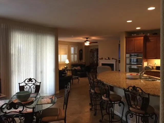 a kitchen with granite countertop a table chairs stove and cabinets