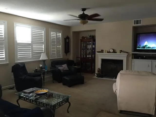 a backyard of a house with table and chairs with plants