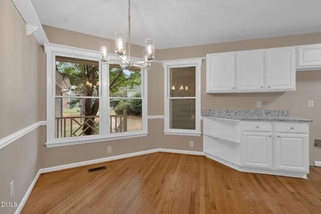 a view of an empty room with a chandelier fan