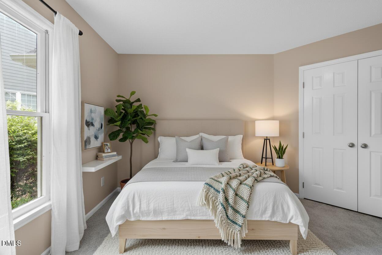 42 Renwick Court Raleigh, NC 27615 - Photo 23 of 58 a bedroom with a large bed and a potted plant