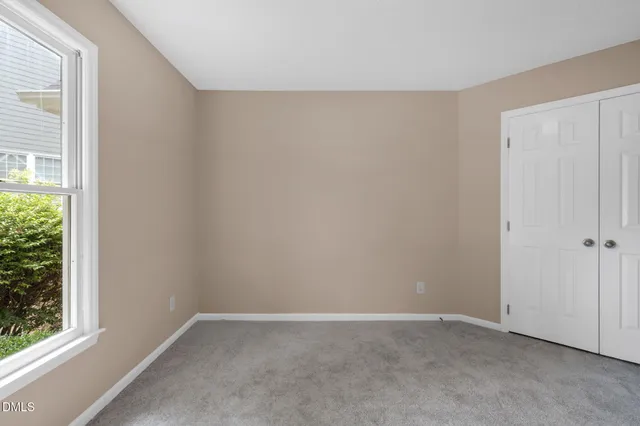 a view of an empty room with chandelier fan
