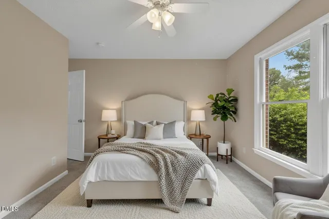 a spacious bedroom with a bed a chandelier and a window