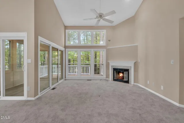 a view of an empty room with stairs and a way to kitchen