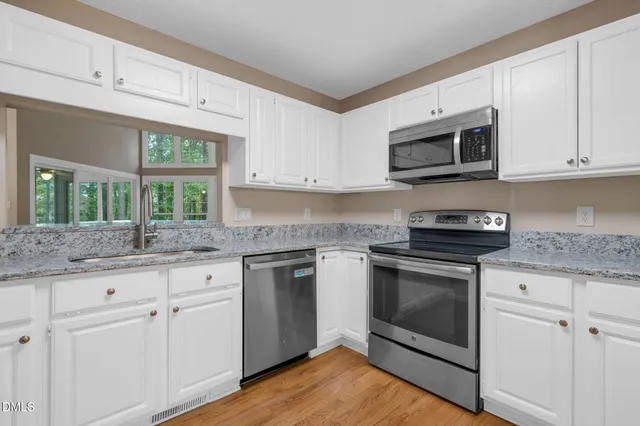 a kitchen with a table chairs and white cabinets
