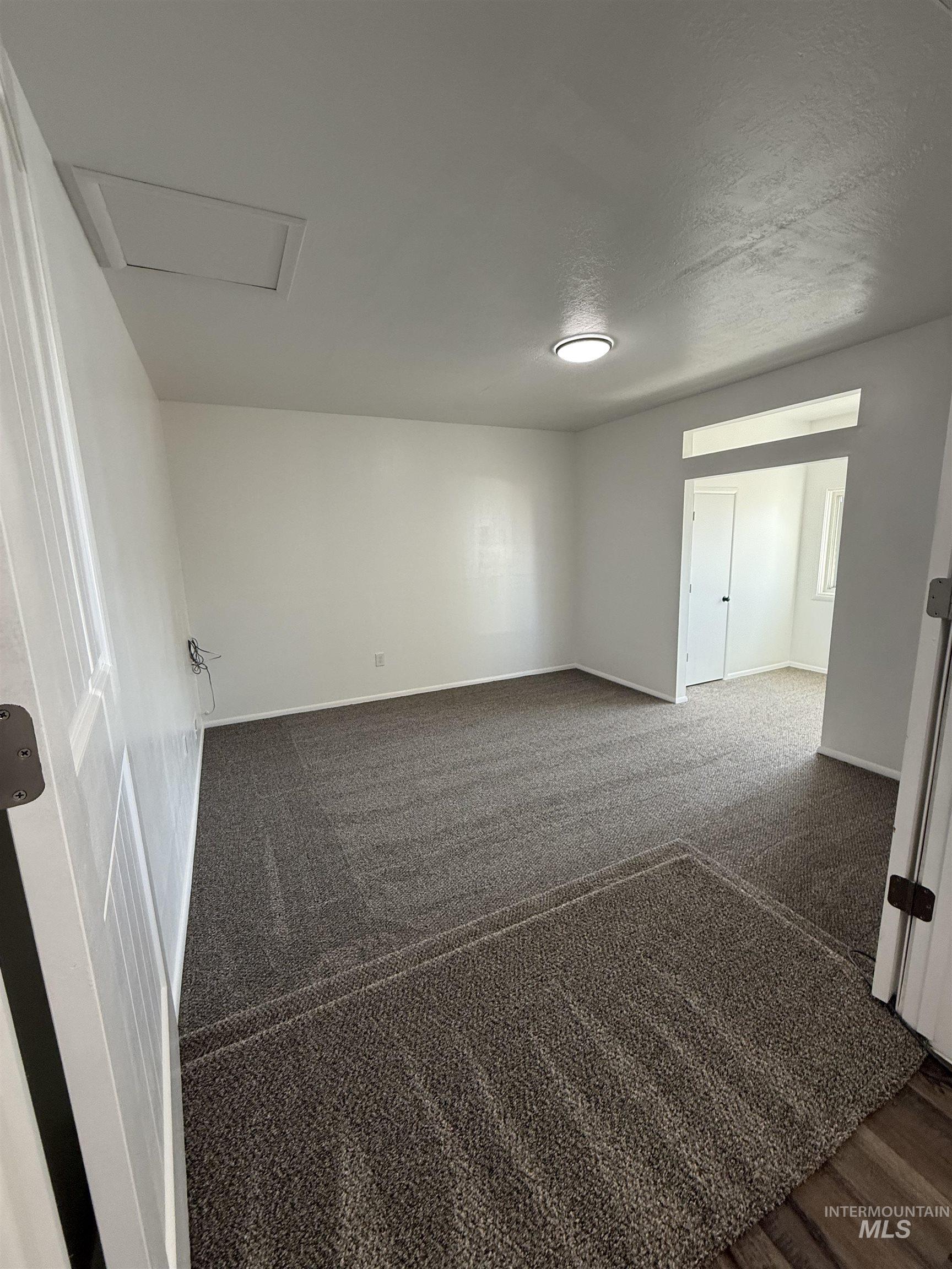 709 Locust Street Kimberly, ID 83341 - Photo 2 of 13 Spare room with dark carpet and baseboards