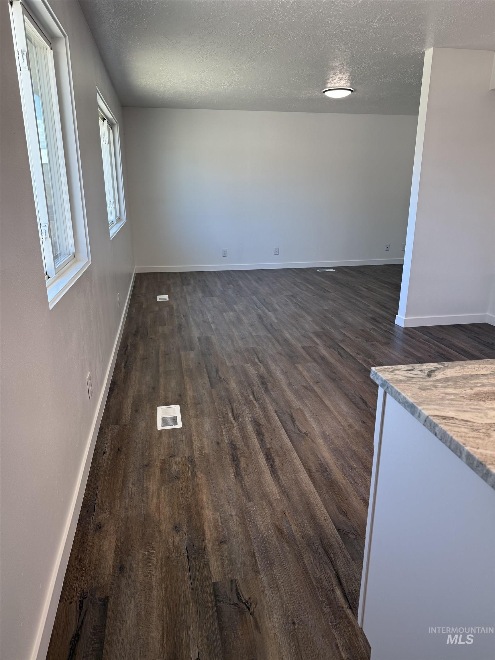 709 Locust Street Kimberly, ID 83341 - Photo 6 of 13 Spare room with dark wood-style floors and a textured ceiling