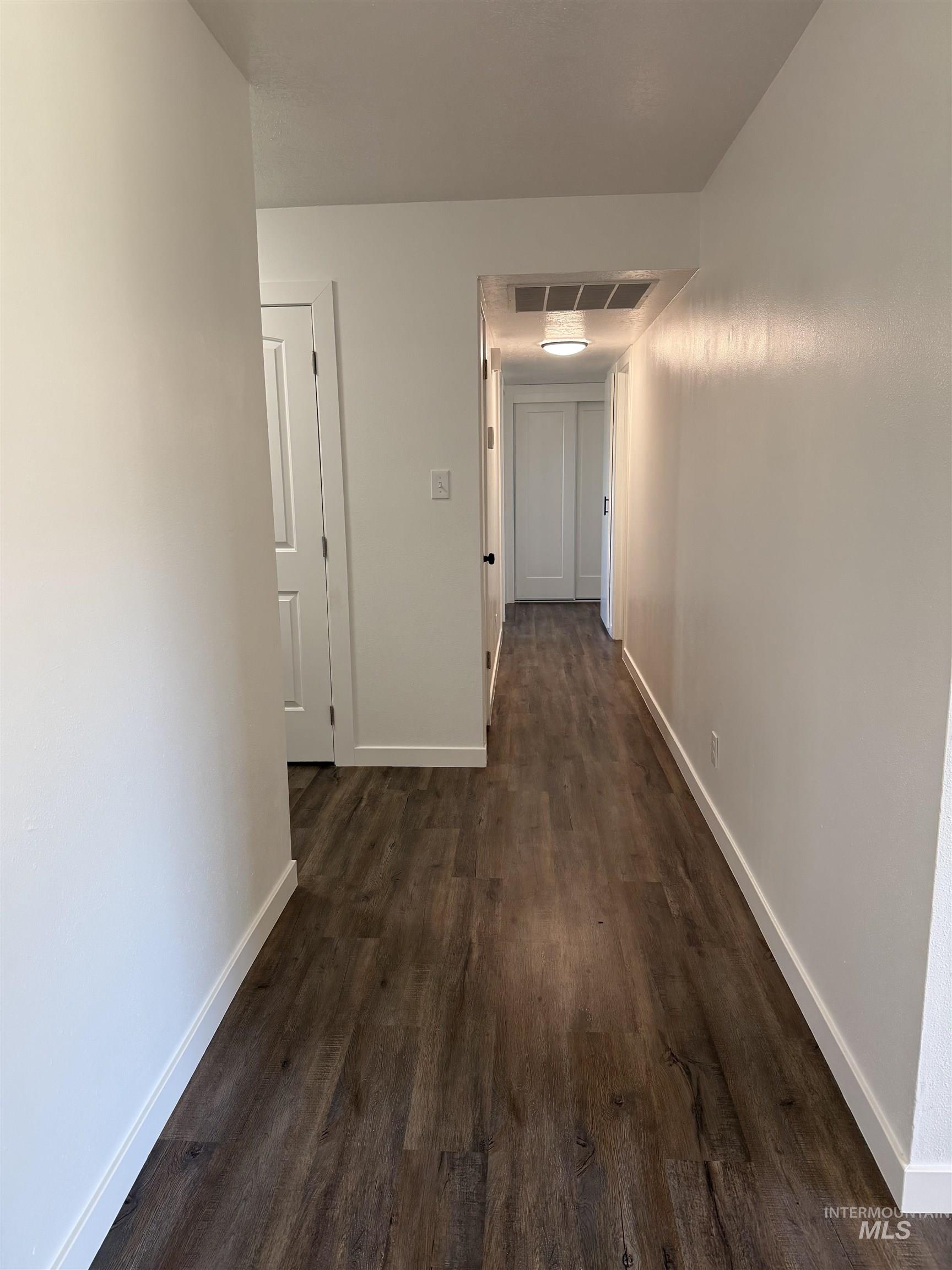 709 Locust Street Kimberly, ID 83341 - Photo 7 of 13 Hallway with dark wood-style flooring and baseboards