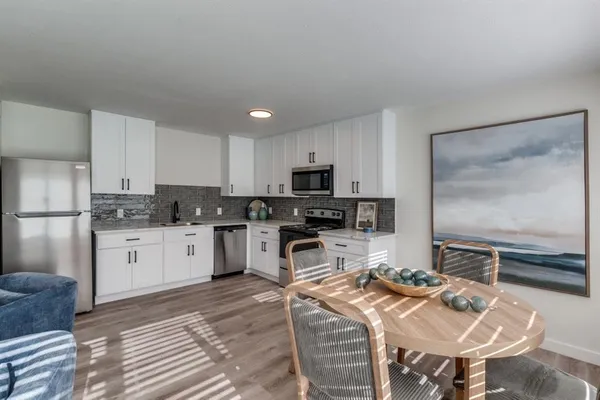 a kitchen with stainless steel appliances kitchen island granite countertop a sink refrigerator and cabinets