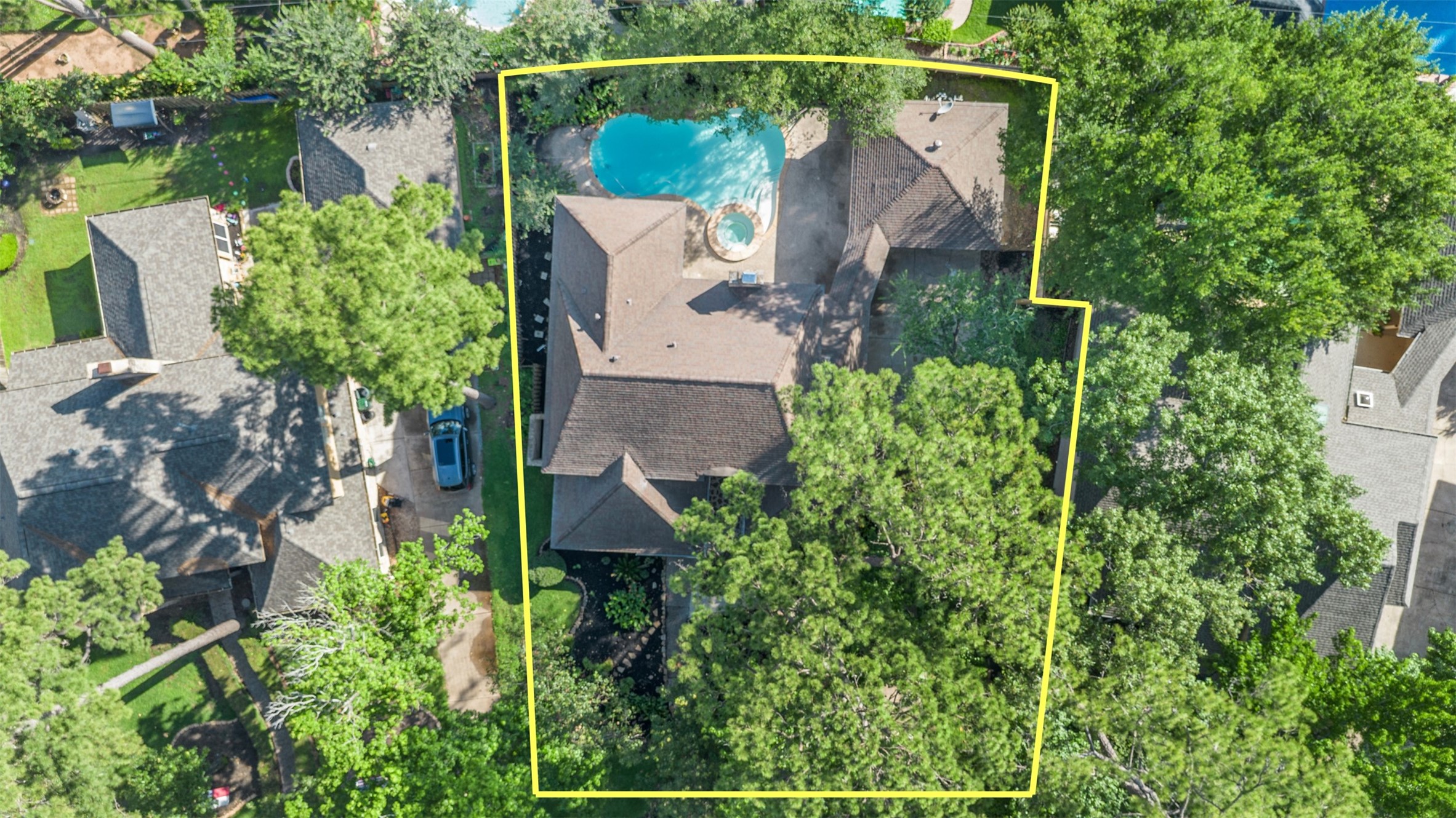 9543 Enstone Circle Spring, TX 77379 - Photo 49 of 50 This aerial view highlights a spacious, tree-lined property with a large house and a backyard pool. The area is well-defined by a yellow border, showcasing privacy and ample outdoor space. Perfect for those seeking a serene residential setting.