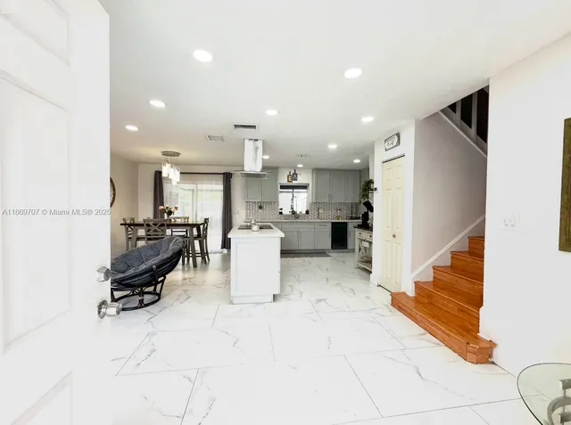 a living room with furniture and a refrigerator