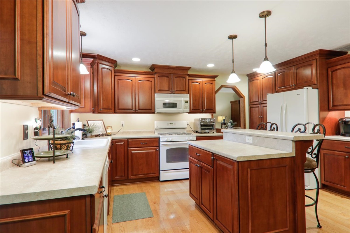 21 Bent Tree Lane Towanda, IL 61776 - Photo 14 of 49 a kitchen with kitchen island granite countertop wooden cabinets and white appliances