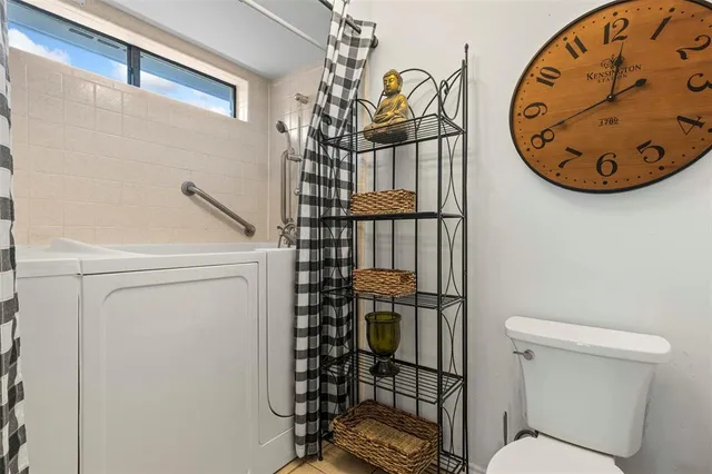 a bathroom with a toilet and a shower