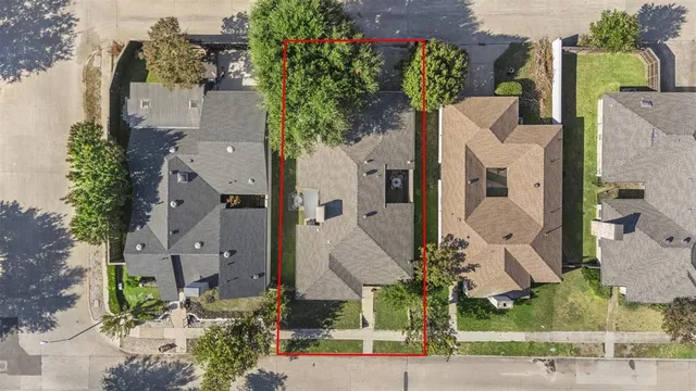 an aerial view of a house with a yard and large trees