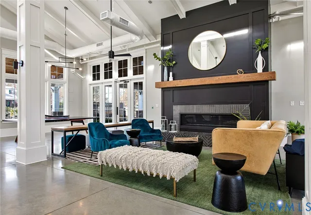 a living room with furniture a fireplace and a floor to ceiling window