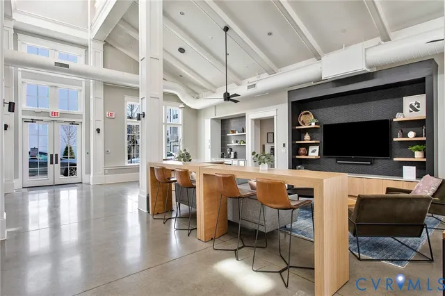 a living room with furniture a flat screen tv and kitchen view