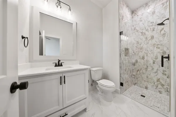 a bathroom with a sink a toilet and shower