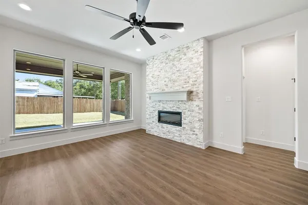 a large kitchen with kitchen island a large counter top space wooden floor and appliances