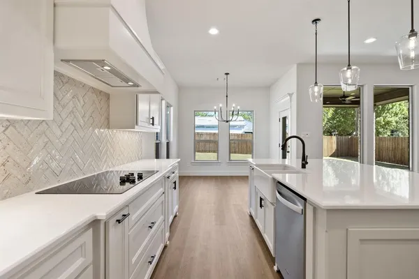 a kitchen with white cabinets appliances and sink