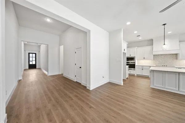 a kitchen with counter top space a sink appliances and windows