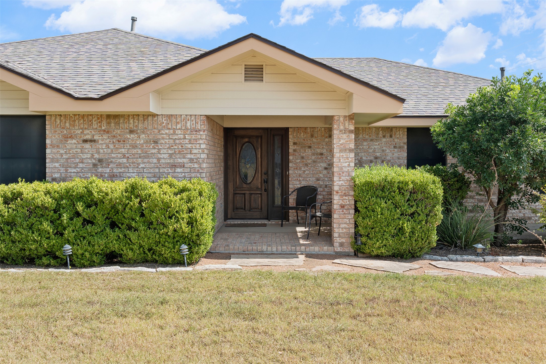1512 Panther Loop Pflugerville, TX 78660 - Photo 5 of 40 A classic brick exterior with a welcoming porch entry and mature landscaping.