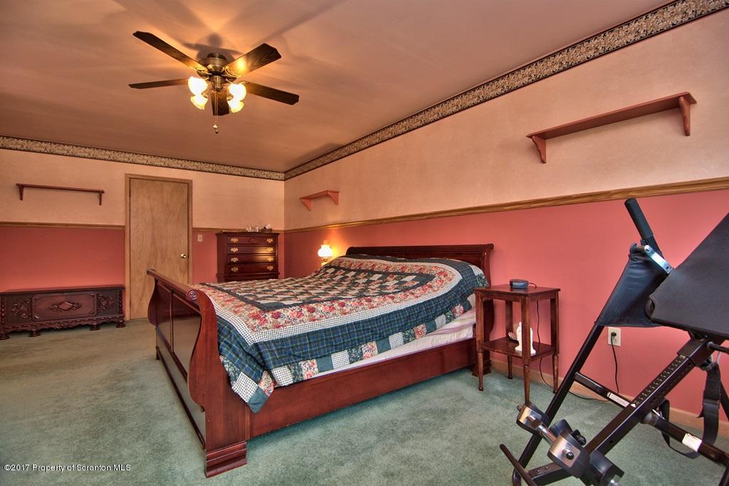 132 Thomas Road Moscow, PA 18444 - Photo 24 of 46 a bedroom with a bed and a chandelier
