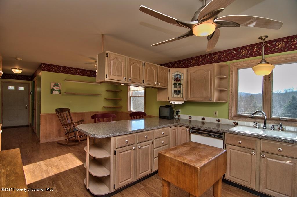 132 Thomas Road Moscow, PA 18444 - Photo 6 of 46 a kitchen with kitchen island granite countertop a sink appliances cabinets and furniture