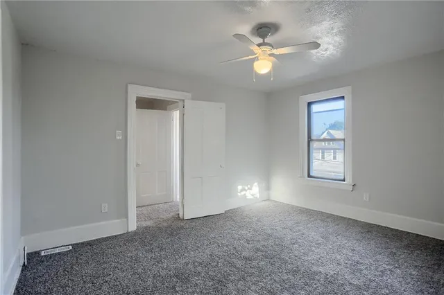 an empty room with fan and windows