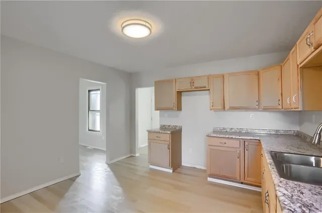 a kitchen with granite countertop white cabinets and white appliances