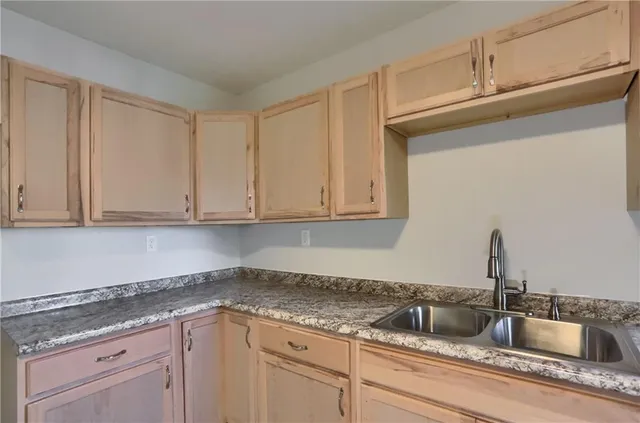 a kitchen with granite countertop white cabinets and a sink