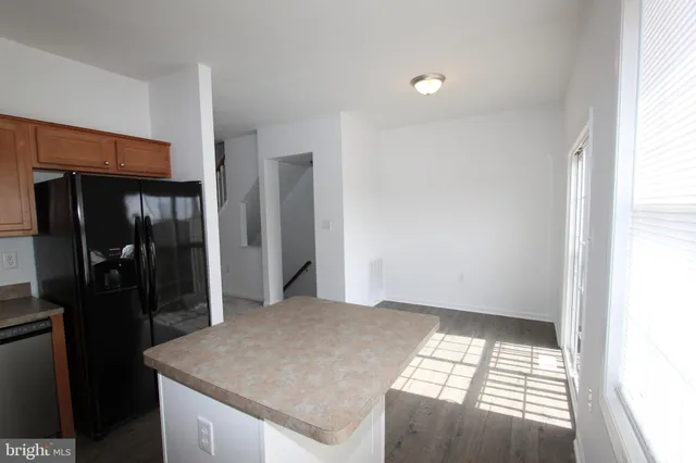a kitchen with white cabinets and refrigerator