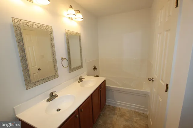 a bathroom with a double vanity sink and mirror with shower