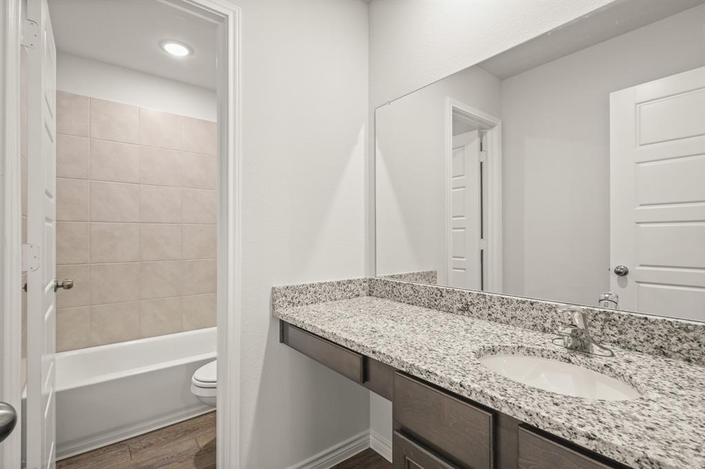 1507 Romans Road Ennis, TX 75119 - Photo 15 of 19 a bathroom with a granite countertop sink and a mirror