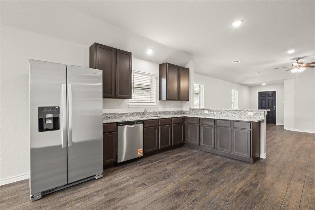 1507 Romans Road Ennis, TX 75119 - Photo 5 of 19 a large kitchen with a refrigerator and a sink