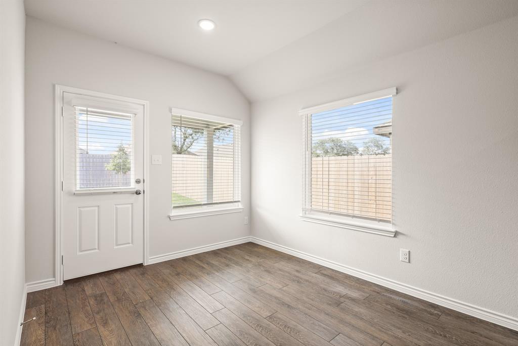 1507 Romans Road Ennis, TX 75119 - Photo 7 of 19 an empty room with wooden floor and windows