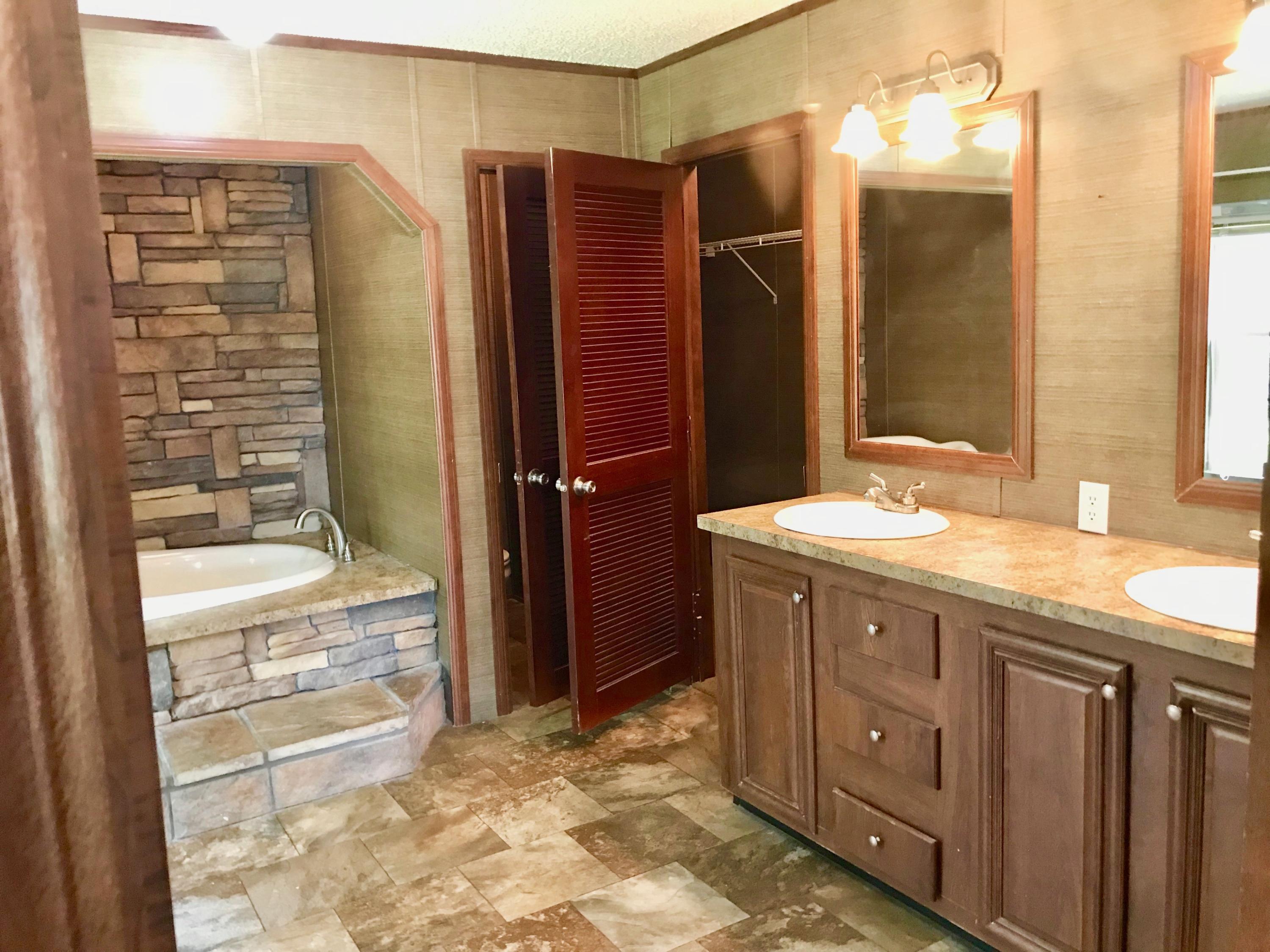 9840 American Farms Road Milton, FL 32583 - Photo 15 of 42 a bathroom with a granite countertop sink shower and a mirror