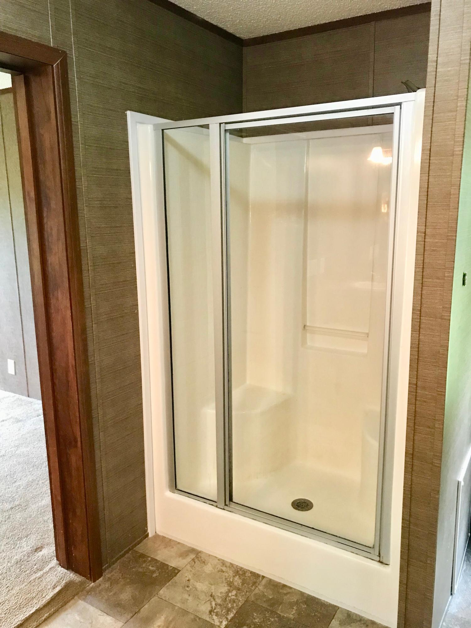 9840 American Farms Road Milton, FL 32583 - Photo 21 of 42 a bathroom with a glass shower door