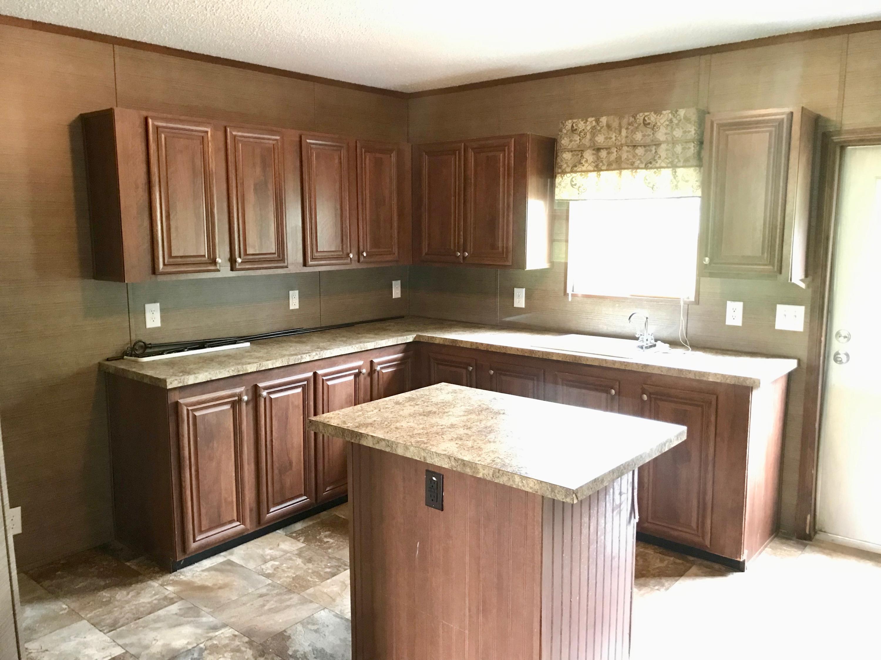 9840 American Farms Road Milton, FL 32583 - Photo 31 of 42 a kitchen with a sink stove and cabinets