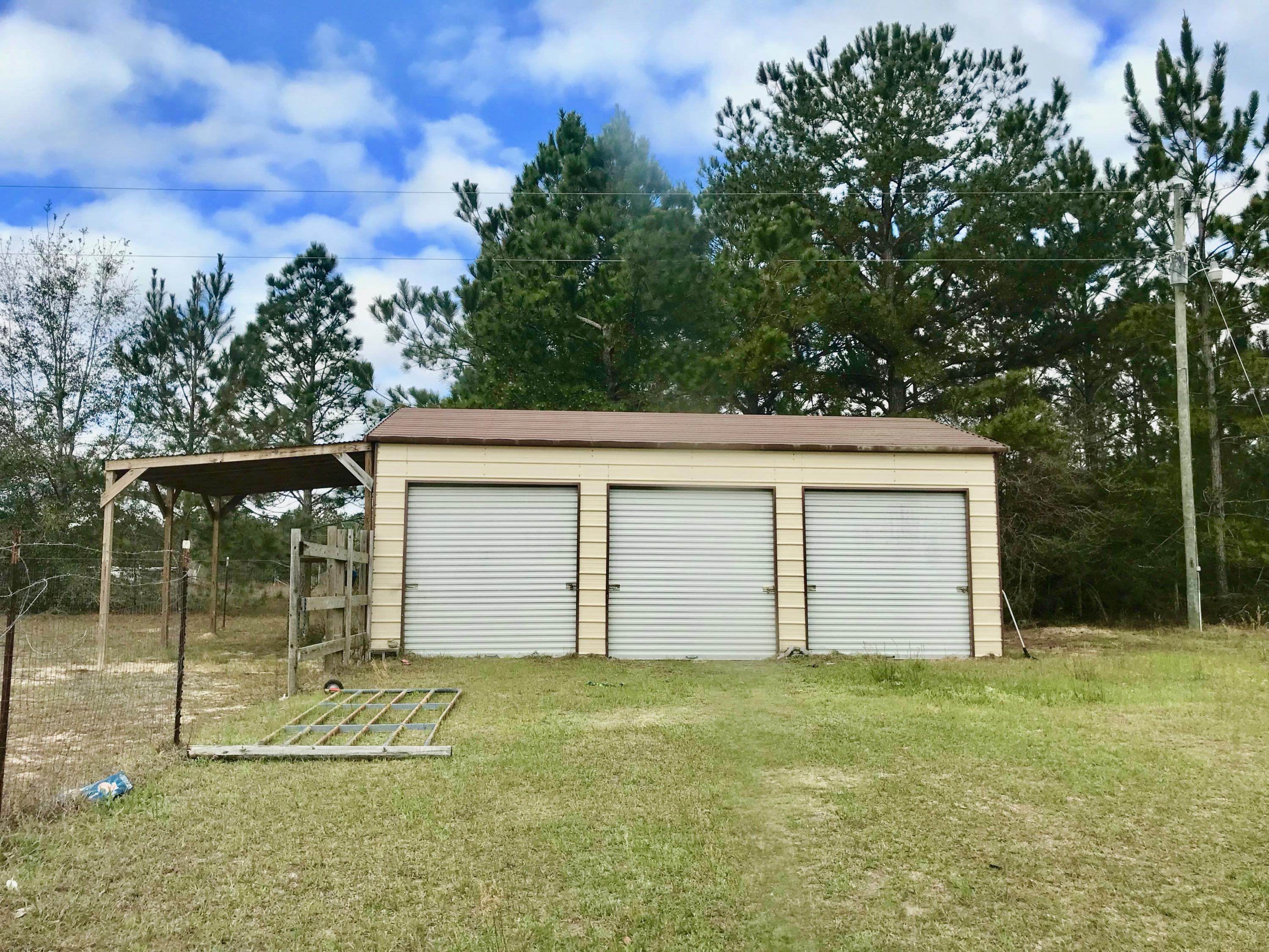 9840 American Farms Road Milton, FL 32583 - Photo 34 of 42 a front view of a house with a garden