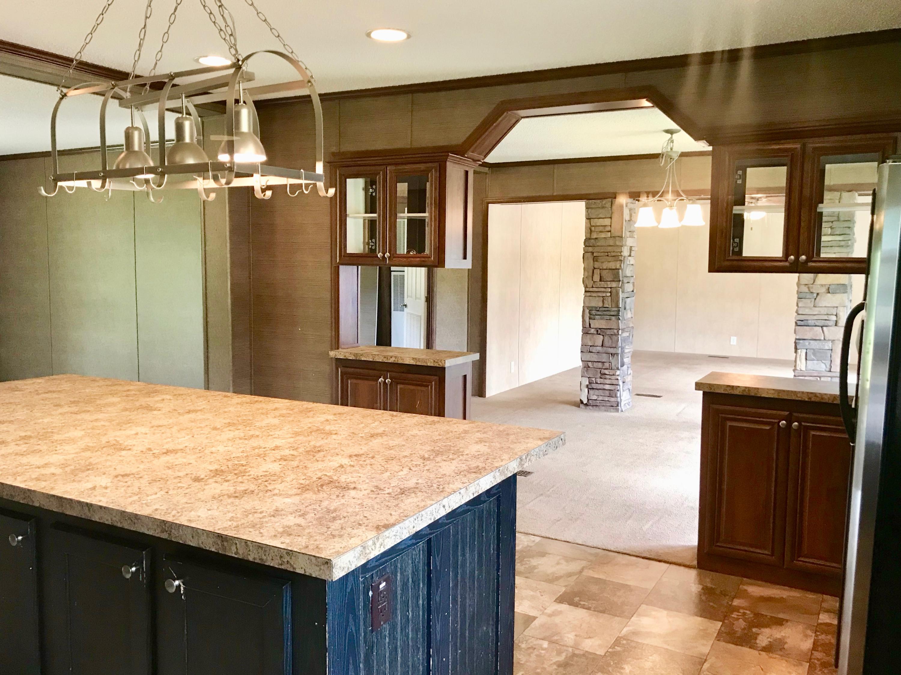 9840 American Farms Road Milton, FL 32583 - Photo 6 of 42 a kitchen with kitchen island a counter top space and a sink