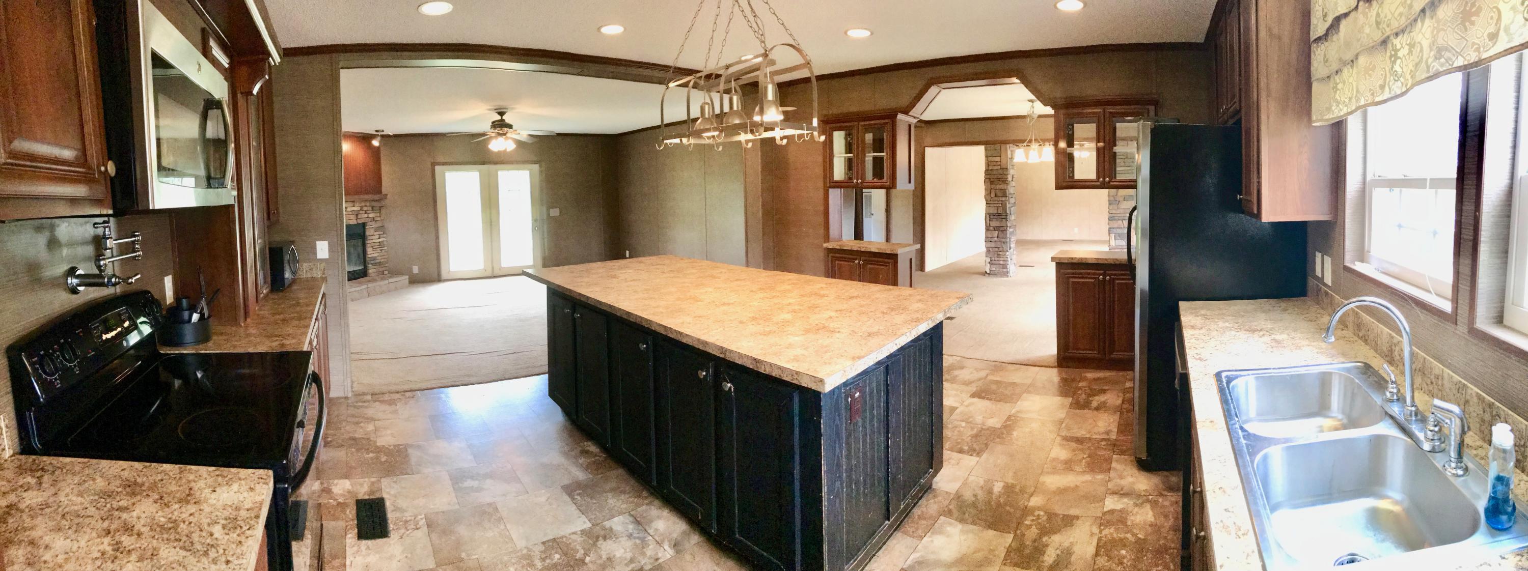 9840 American Farms Road Milton, FL 32583 - Photo 7 of 42 a kitchen with stainless steel appliances kitchen island granite countertop a refrigerator a sink and dishwasher